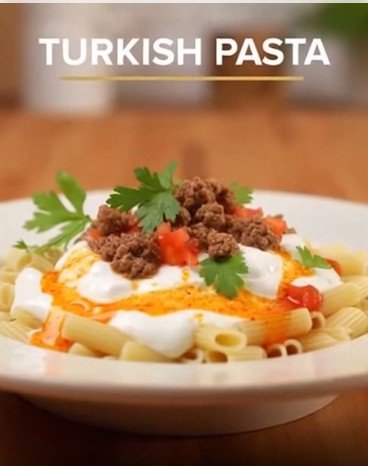 Plate of penne pasta topped with yogurt, ground beef, diced peppers and fresh parsley; 'TURKISH PASTA' title above.